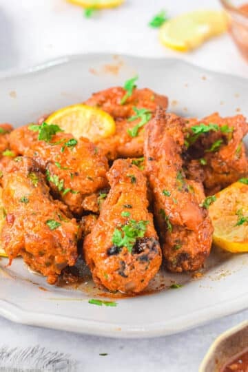 Honey coated chicken wings in a white bowl.