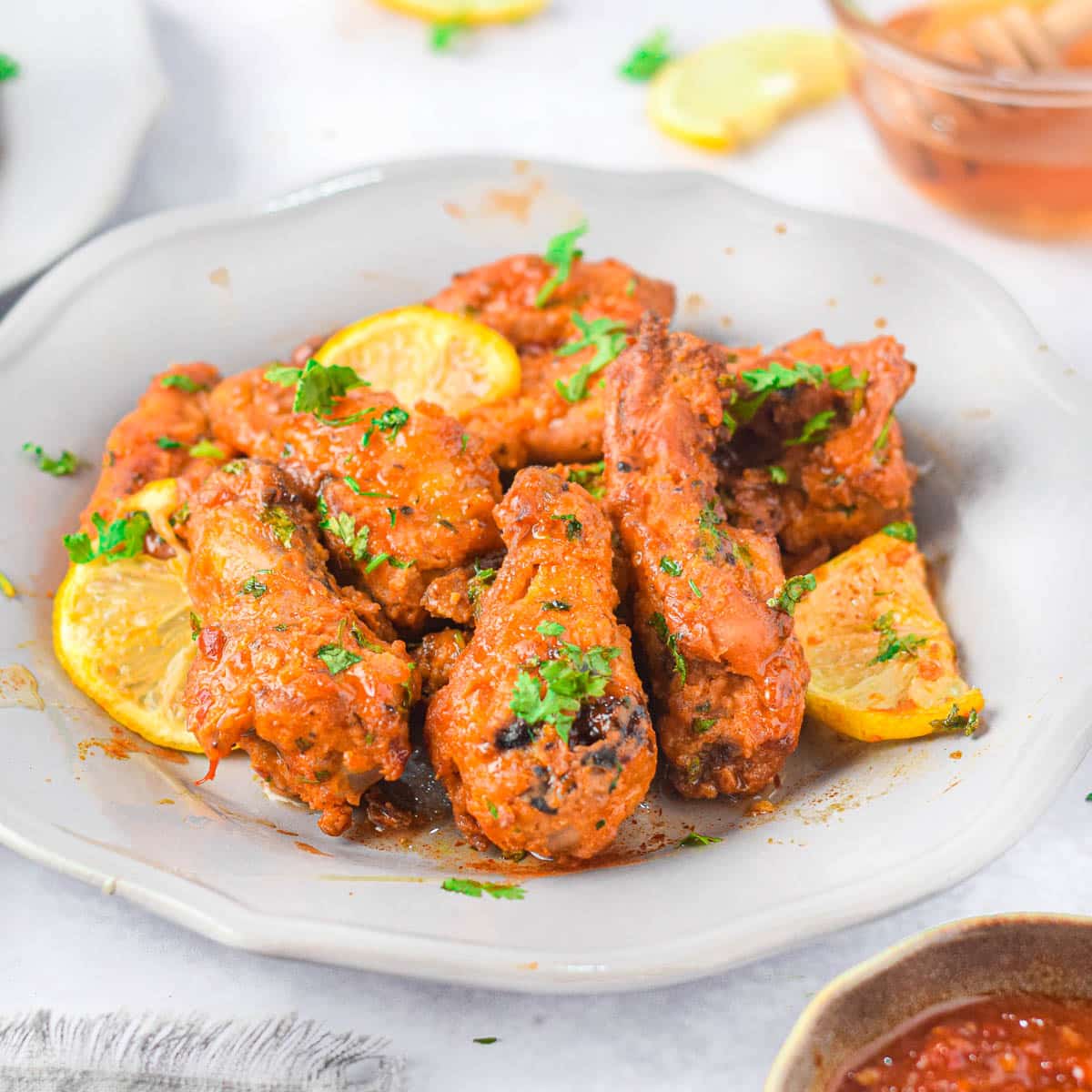 Honey coated chicken wings in a white bowl.