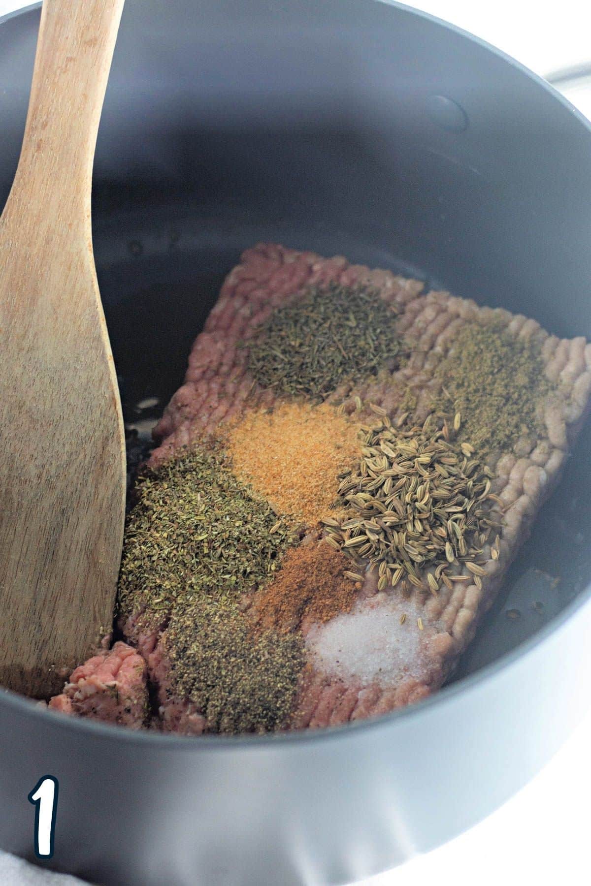 Ground turkey and spices in a large pot.