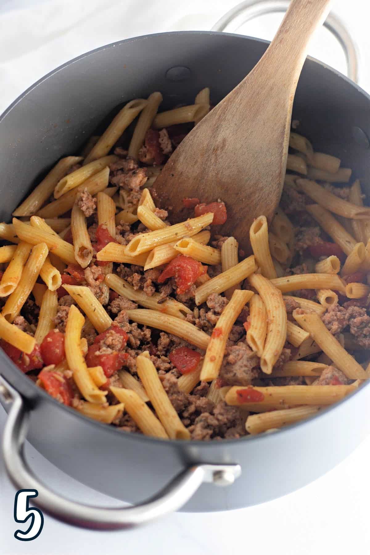 Ground turkey sausage and pasta in a large pot.