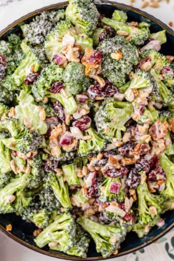 Broccoli Salad in a black bowl next to sunflower seeds.