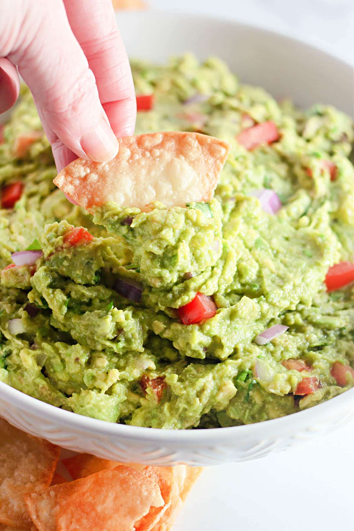 A chip being dipped into fresh guacamole. 
