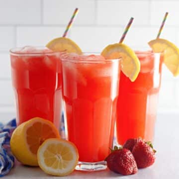 Three glasses of strawberry lemonade with straws.