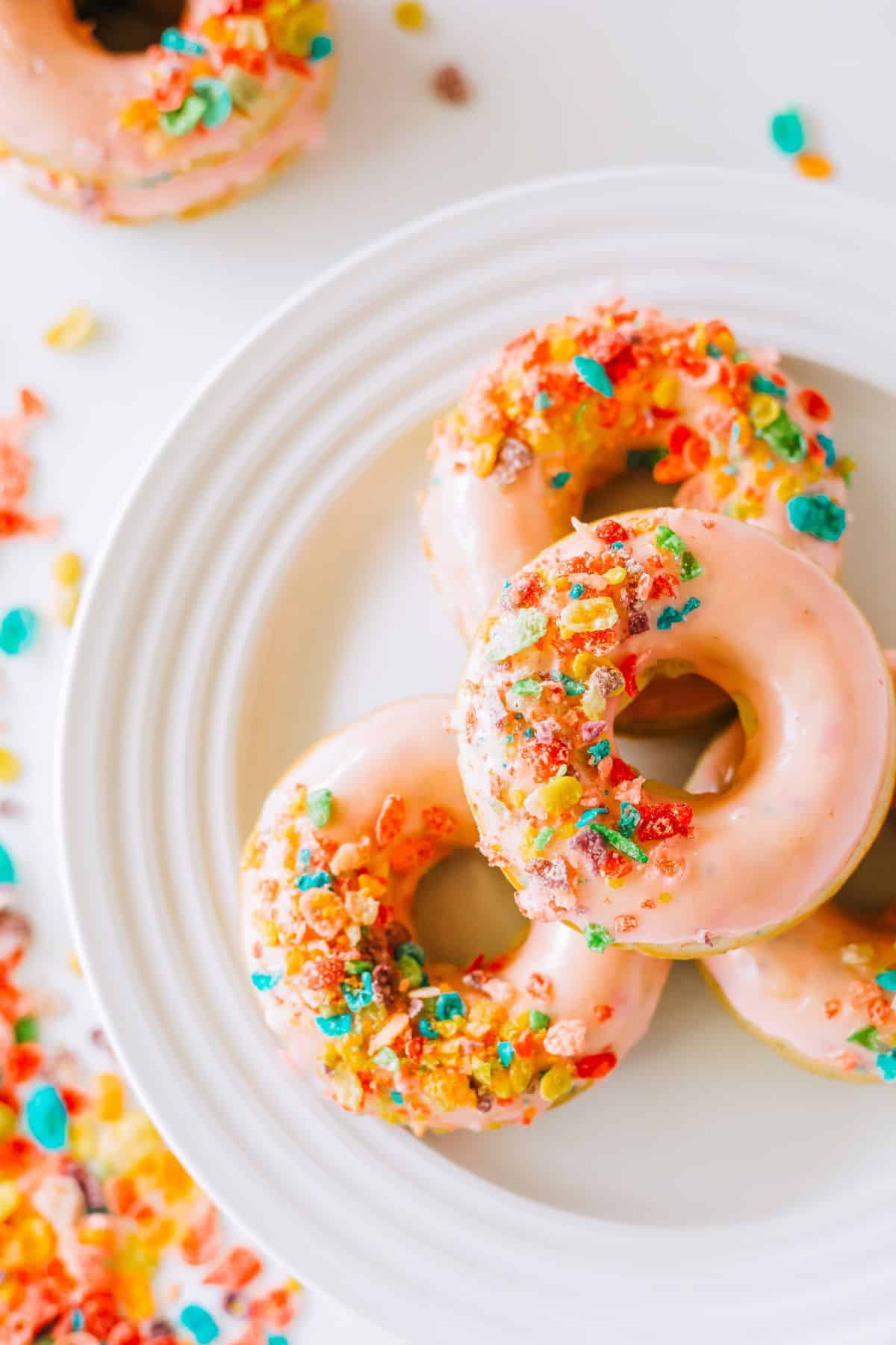 4 Fruity Pebble Cereal Donuts on a white plate. 