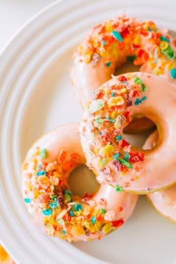 4 Fruity Pebble Cereal Donuts on a white plate.