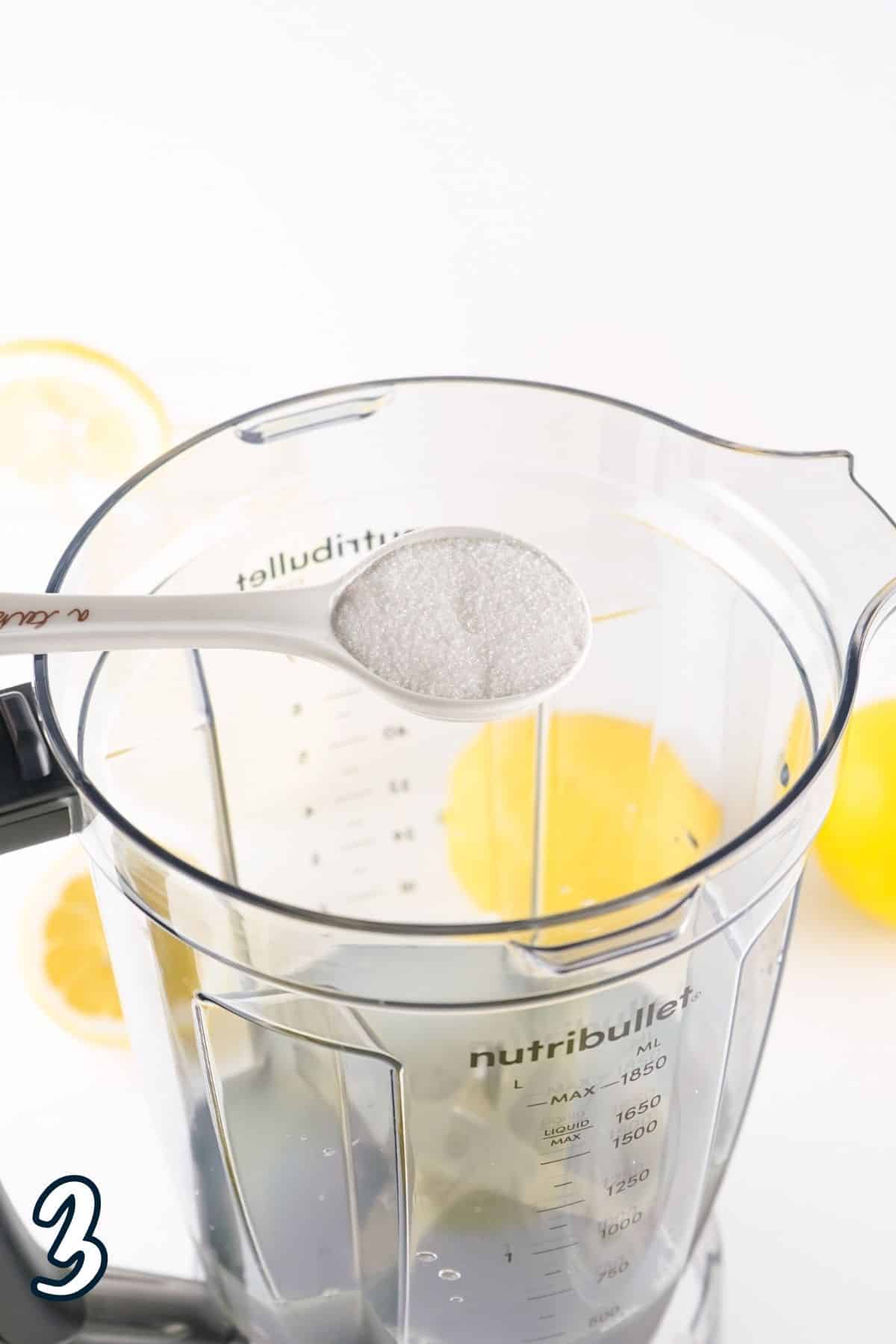Sugar being poured into a blender. 