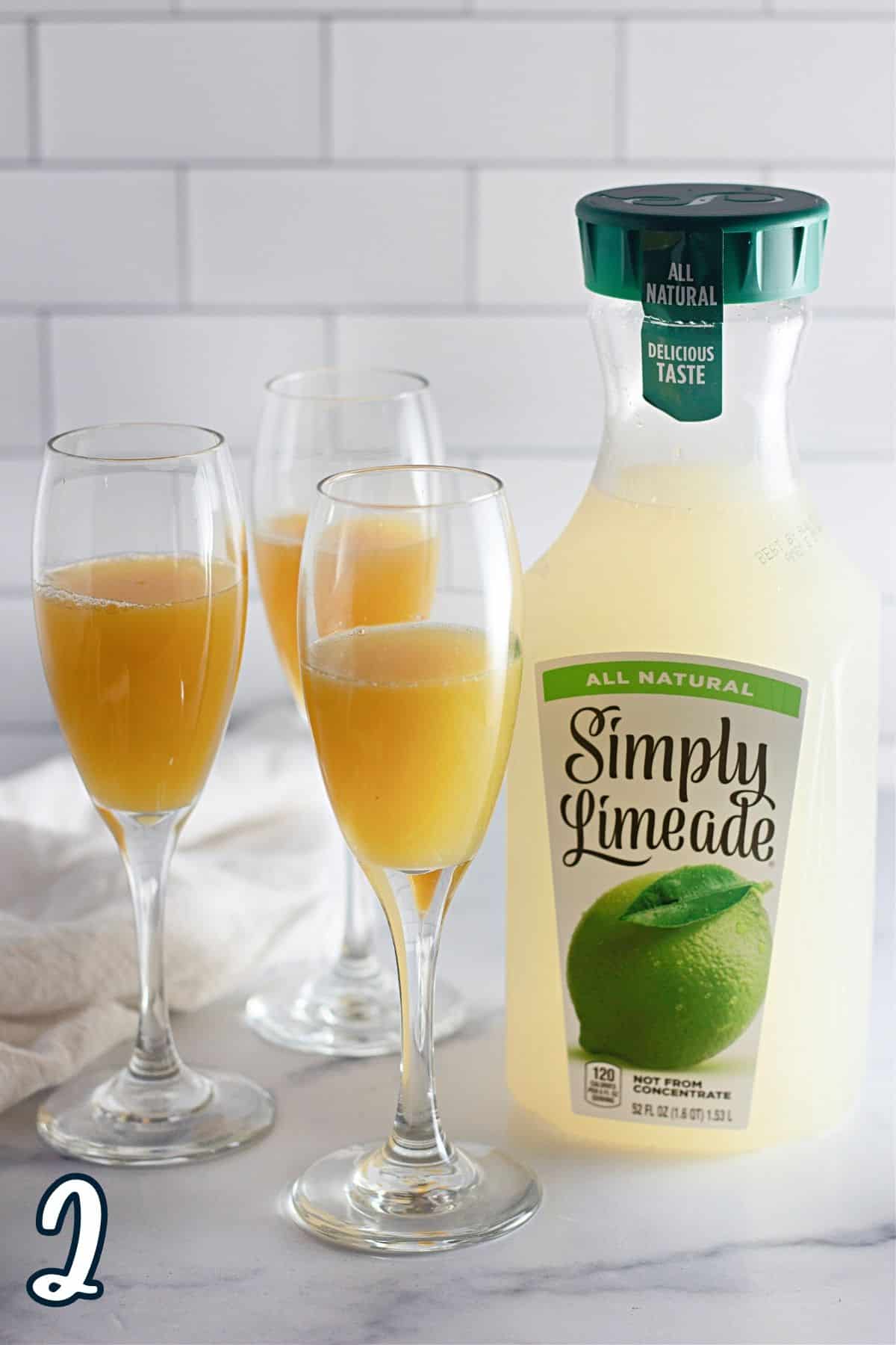 Limeade mixed with orange juice in champagne flutes