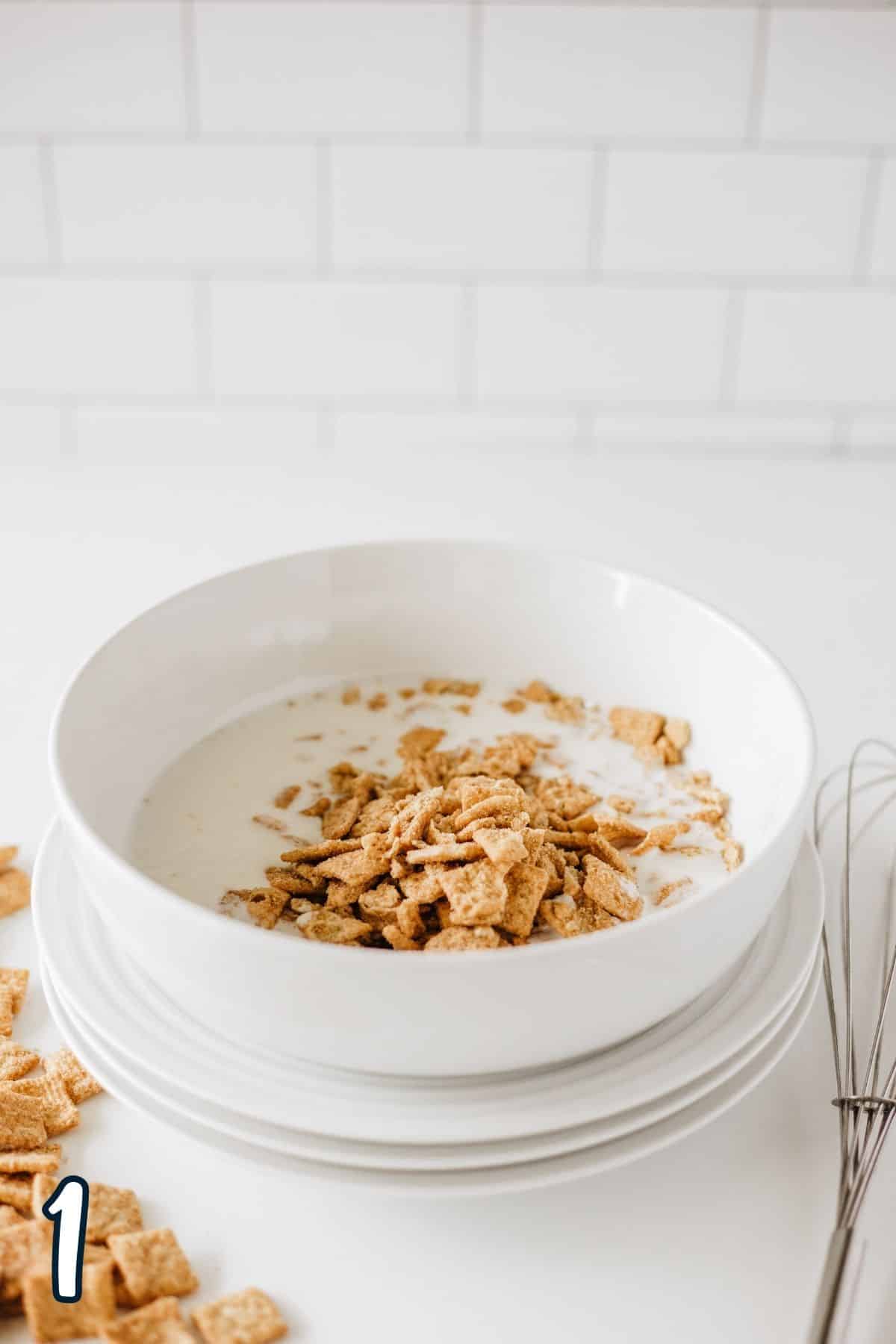 Cinnamon toast crunch cereal and buttermilk in a white mixing bowl. 