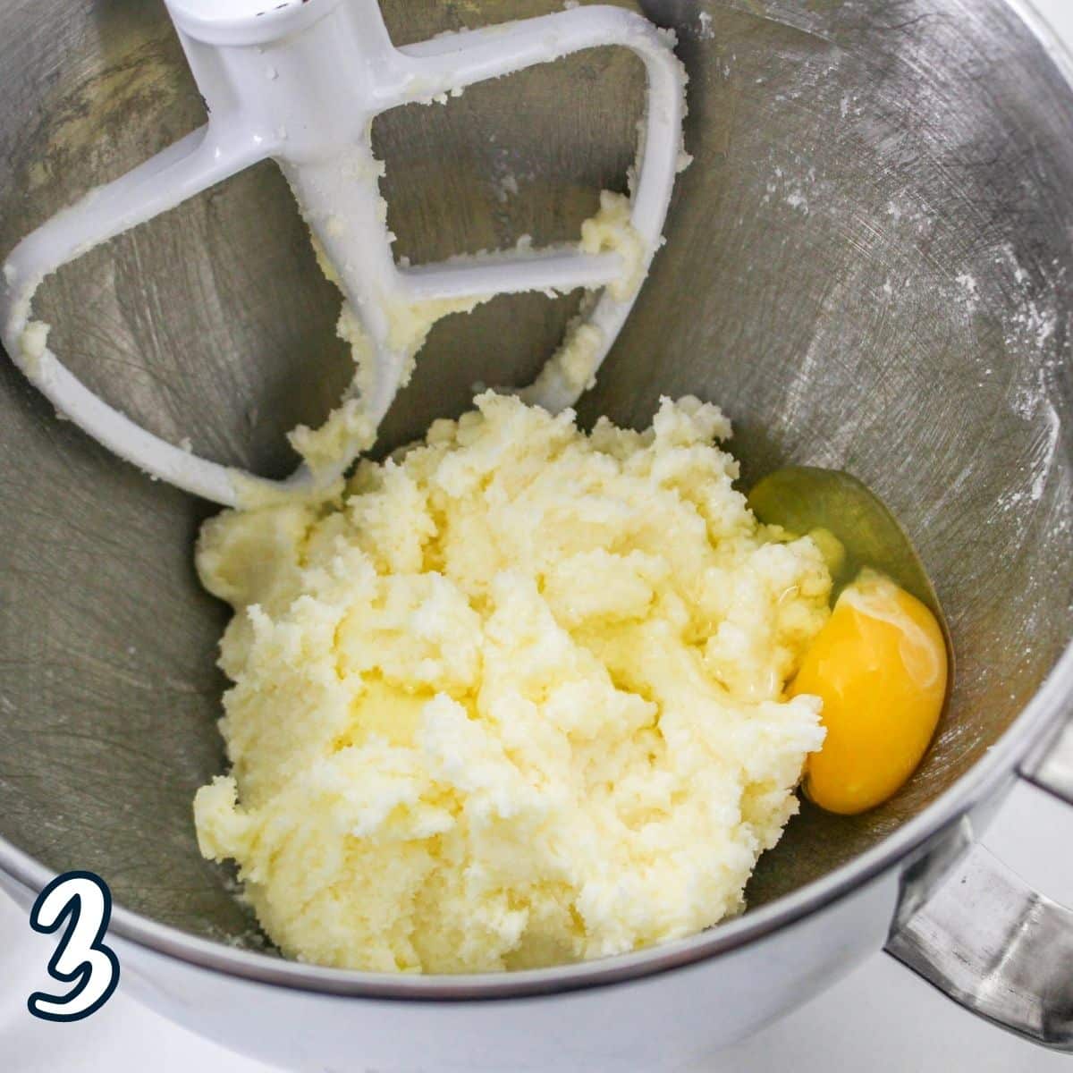Whipped butter and sugar with an egg in a mixing bowl. 