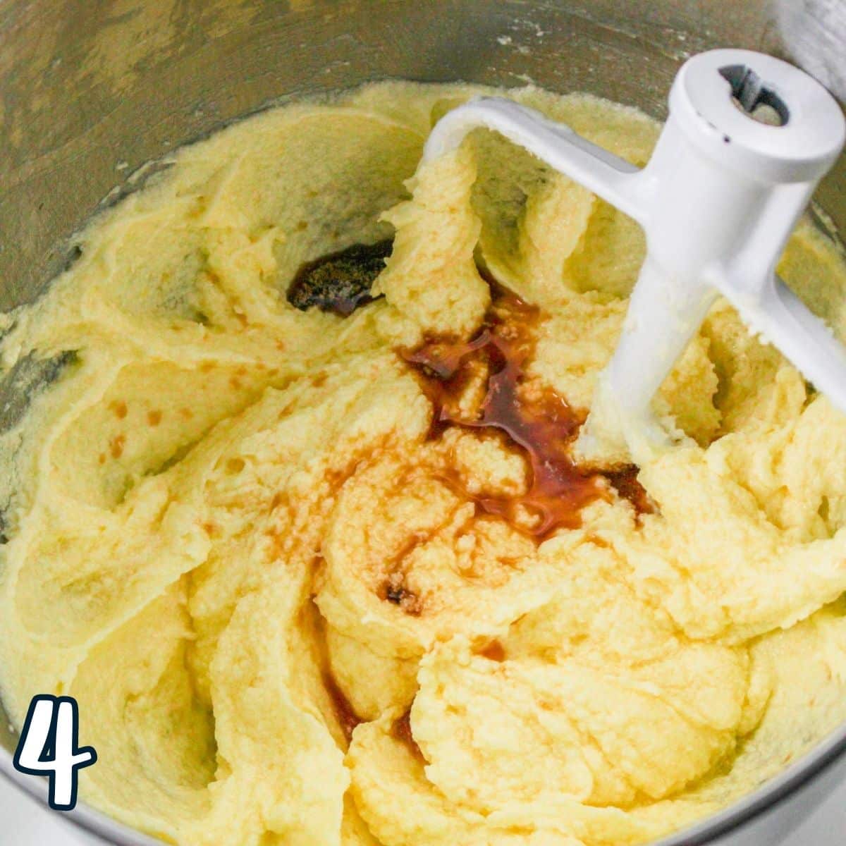 Whipped butter, sugar, and eggs with vanilla in a mixing bowl. 
