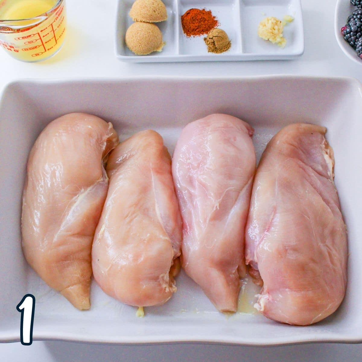 Raw chicken breasts in a casserole dish. 