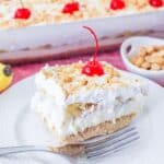 A square of banana split cake on a white plate.