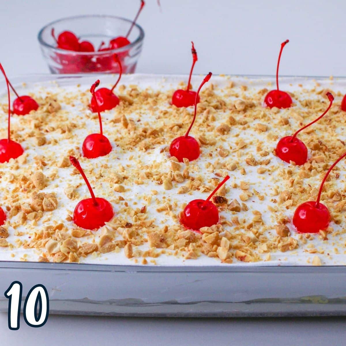 Crushed peanuts and a maraschino cherries as the final layer of the banana split cake. 