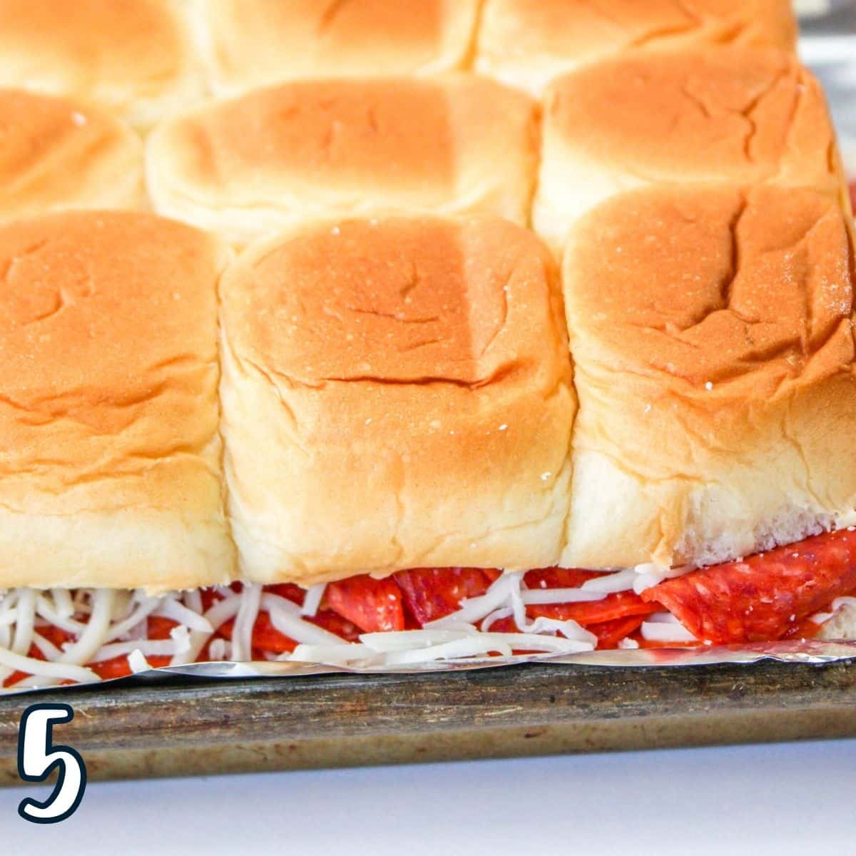 The dinner roll tops over the pizza sliders. 