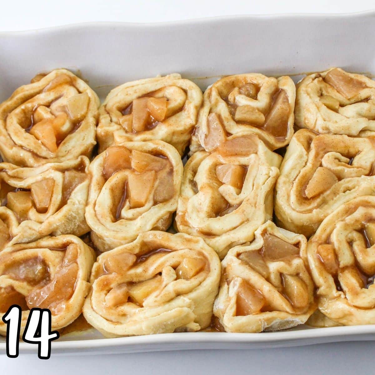 Sliced apple roll dough in a baking dish. 