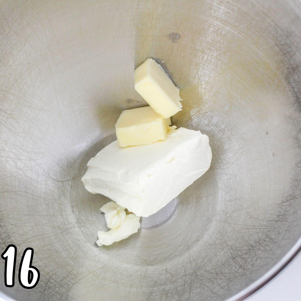 Cream cheese and butter in a metal mixing bowl. 