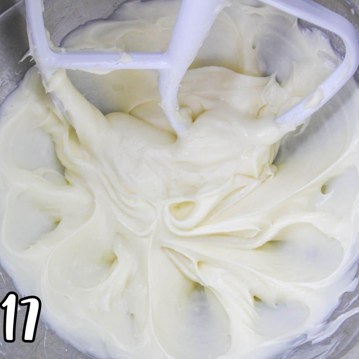Cream cheese frosting in a metal mixing bowl. 