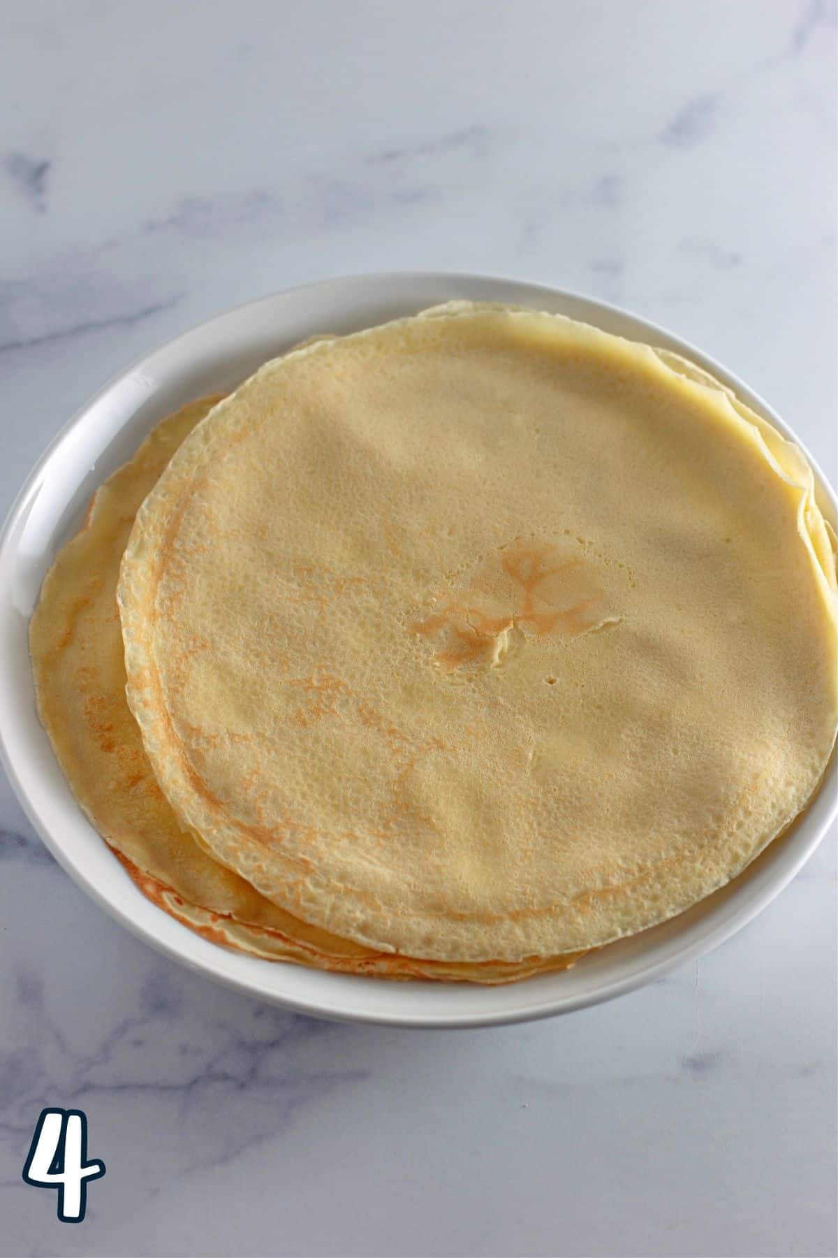 A stack of crepes on a white plate. 