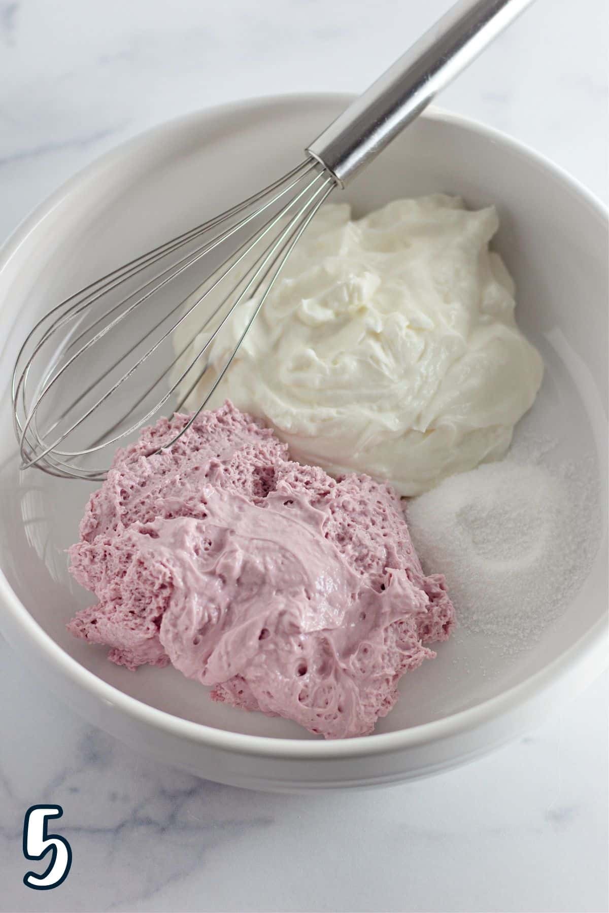 Flavored whipped cream cheese, sugar, and Greek yogurt in a white bowl. 