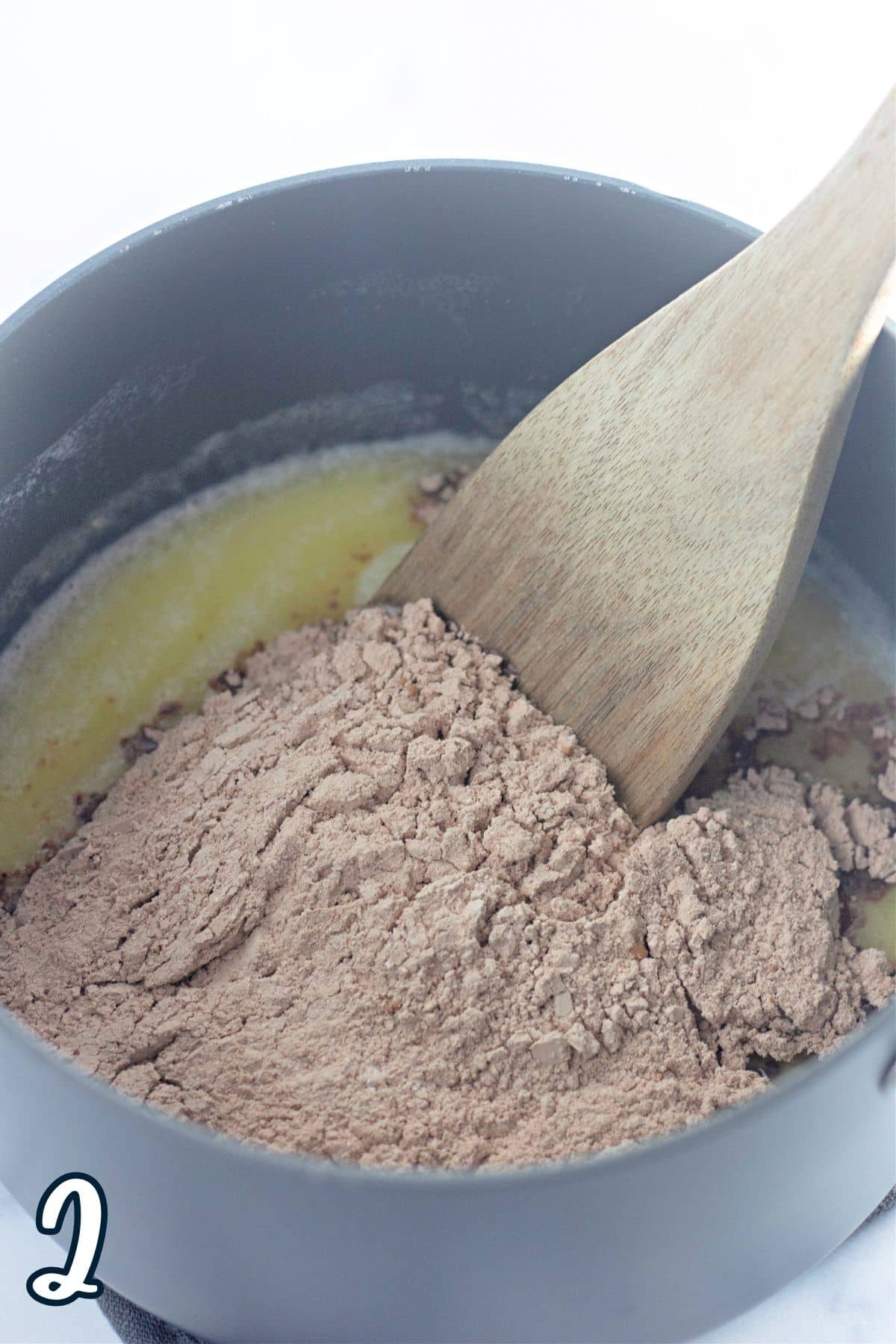 Melted butter with water in a sauce pan topped with a cocoa flour mixture. 