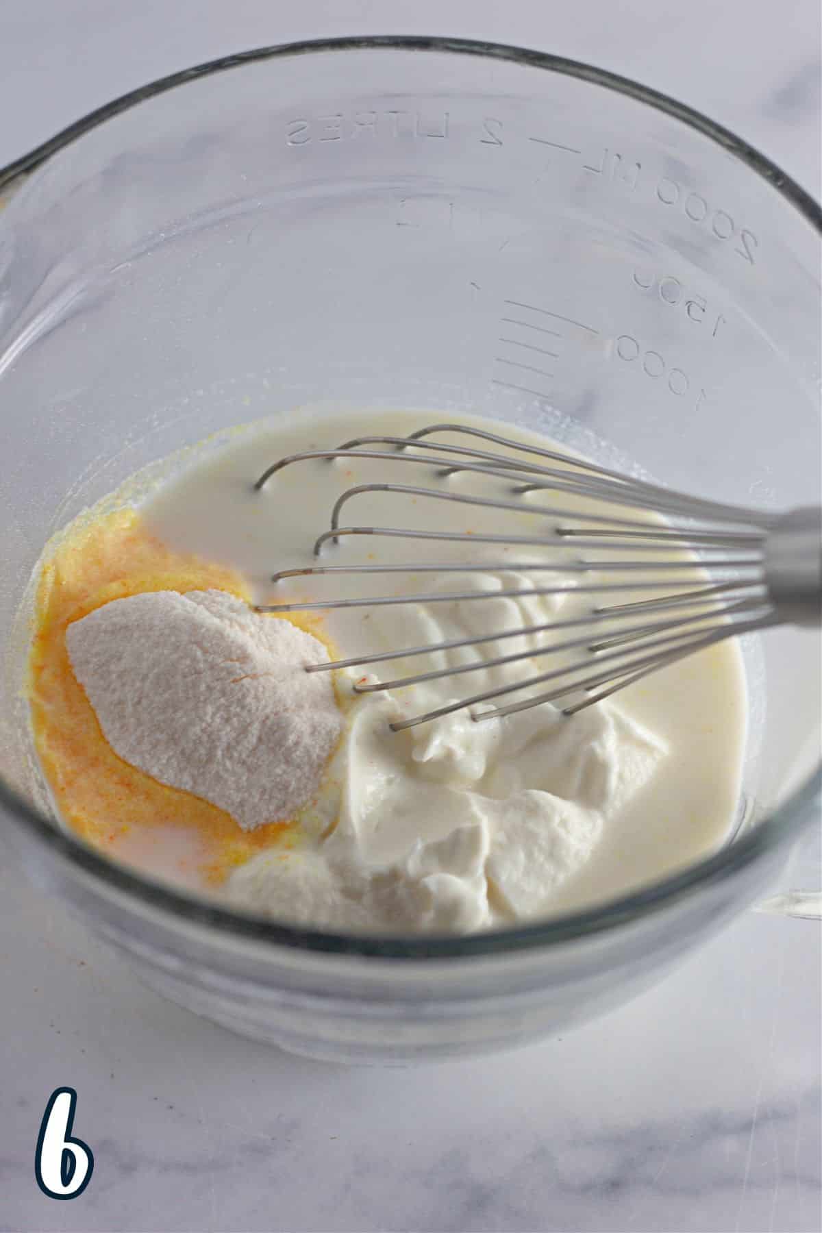 Vanilla pudding mix, milk, and Greek yogurt in a glass mixing bowl. 