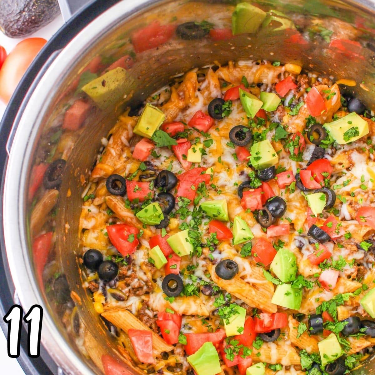 Tomato and avocado garnished taco pasta in a pot. 