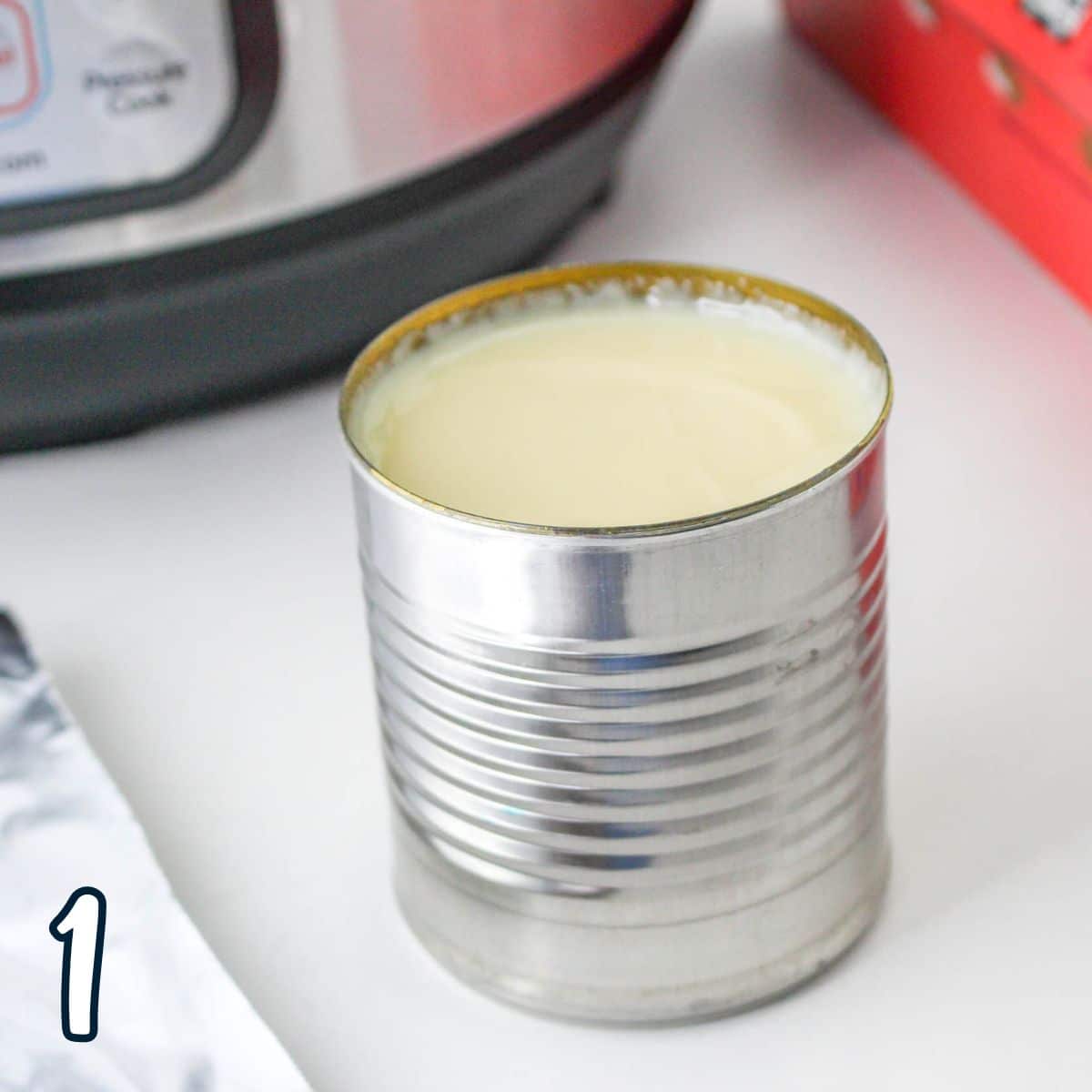 An opened can of sweetened condensed milk next to an instant pot. 