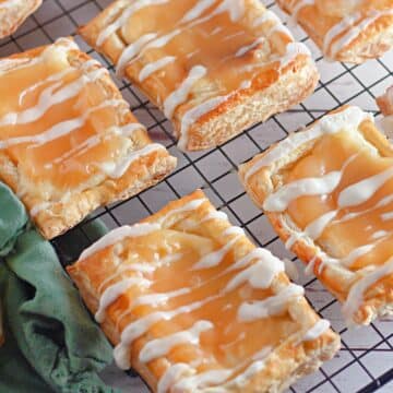 Puff pastry danish with cream cheese and lemon curd on a black rack.