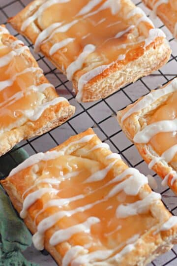 Puff pastry danish with cream cheese and lemon curd on a black rack.