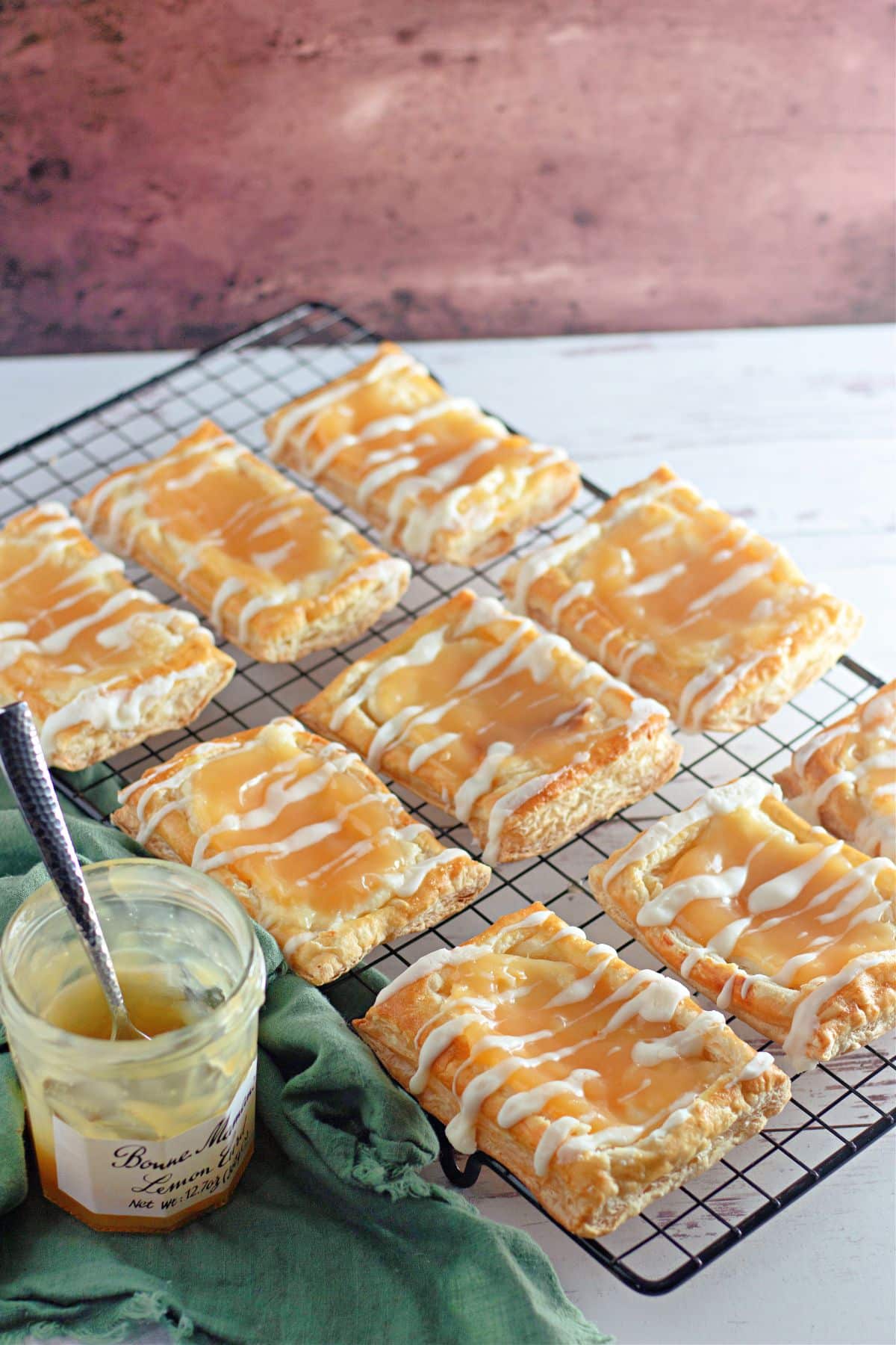 Puff pastry danish with cream cheese and lemon curd on a black rack.
