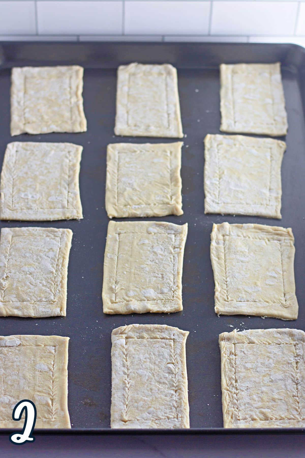 Puff pastry cut into small rectangles on a baking sheet. 