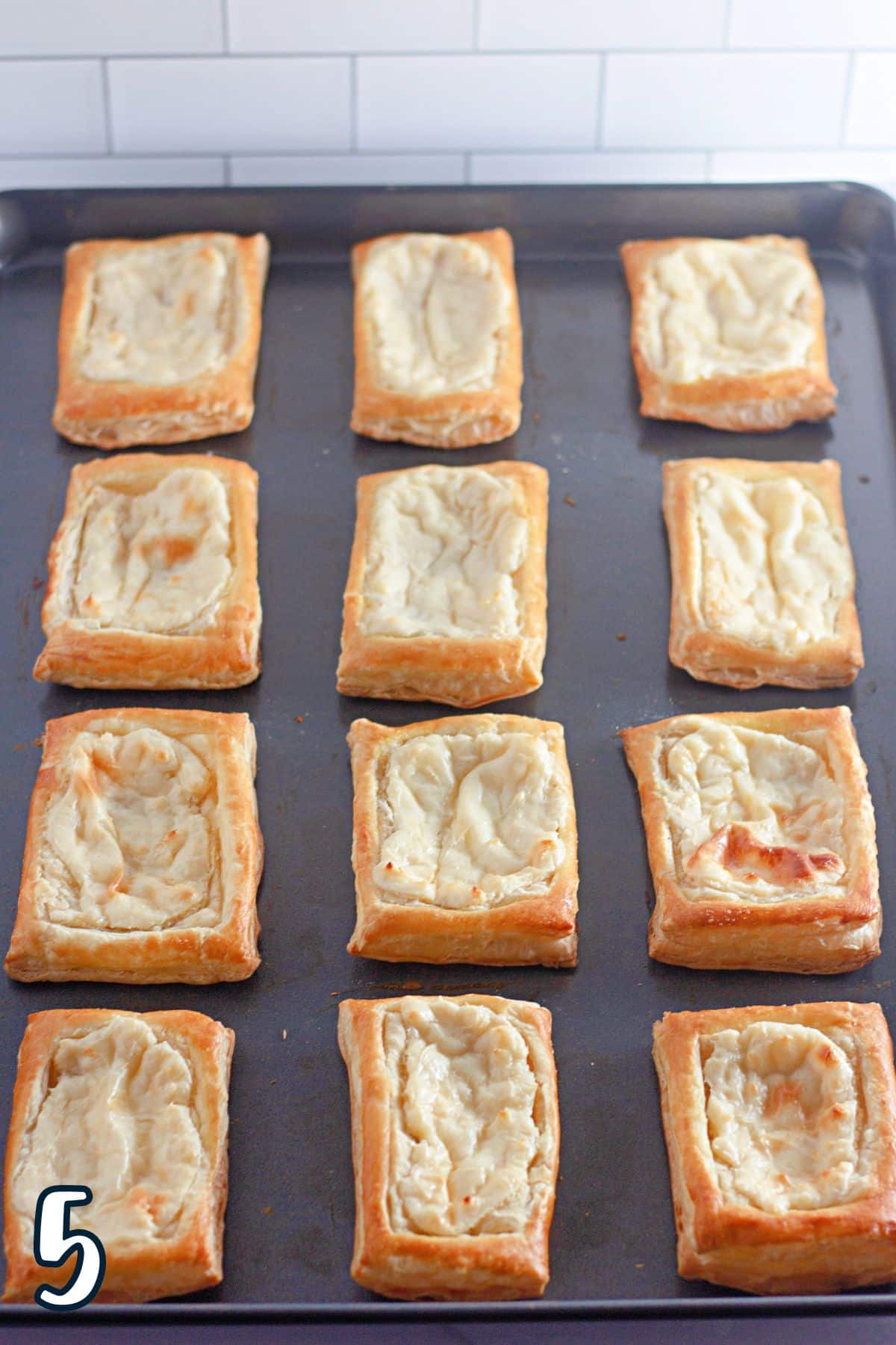 Just baked pastries with cream cheese filling on a baking sheet. 