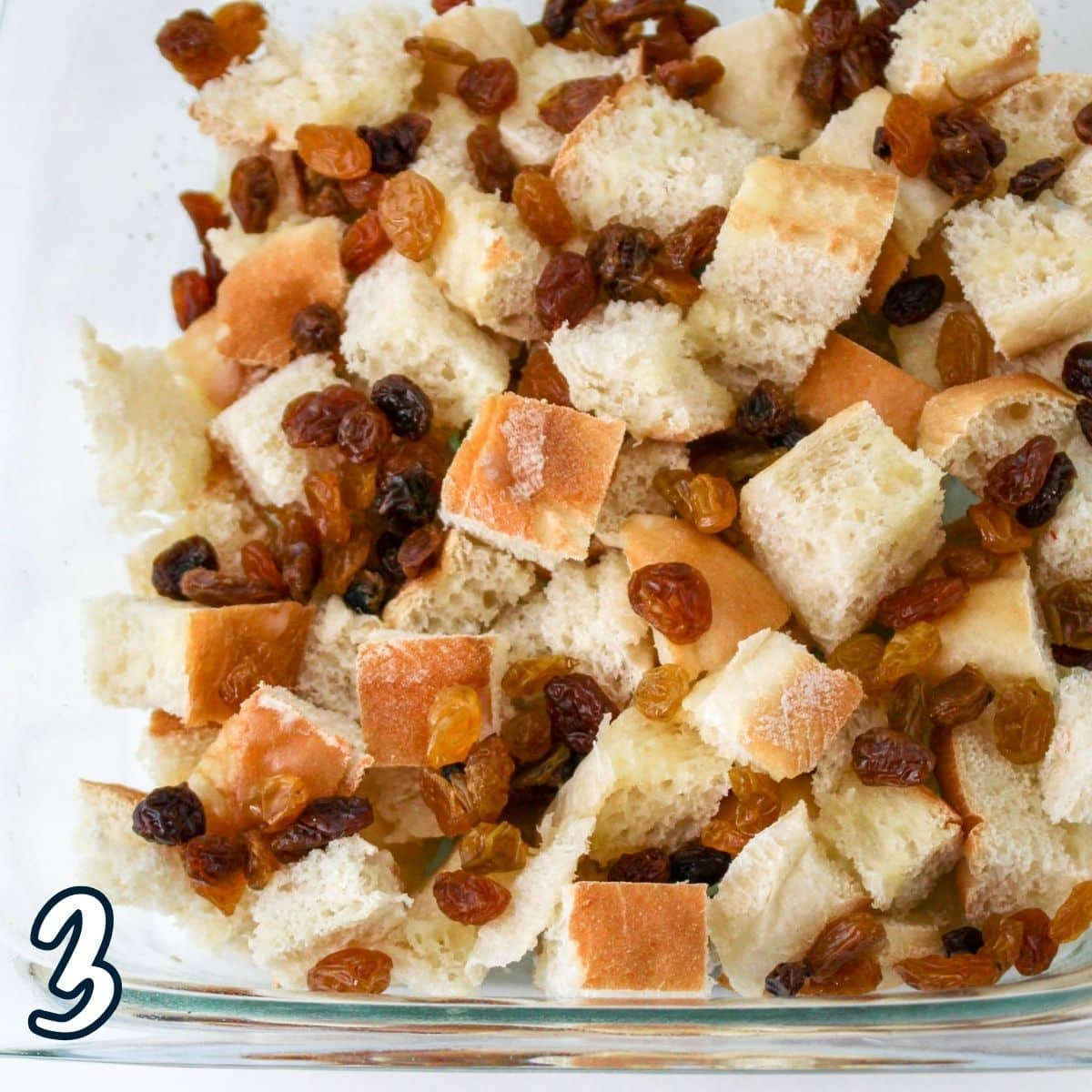 Raisins with bread cubes in a baking dish. 