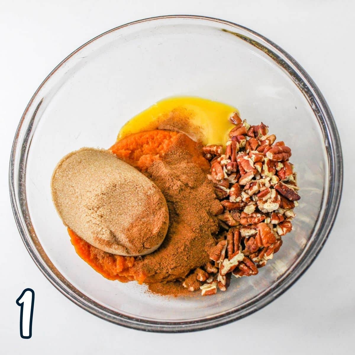 Brown sugar, pumpkin puree, egg, pecans and spices in a bowl. 