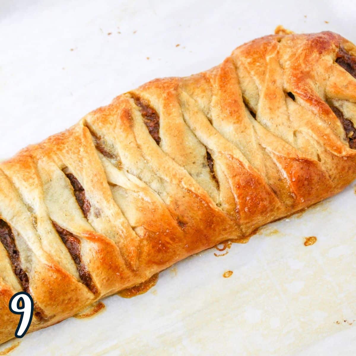 A golden brown, just baked pastry braid filled with pumpkin. 