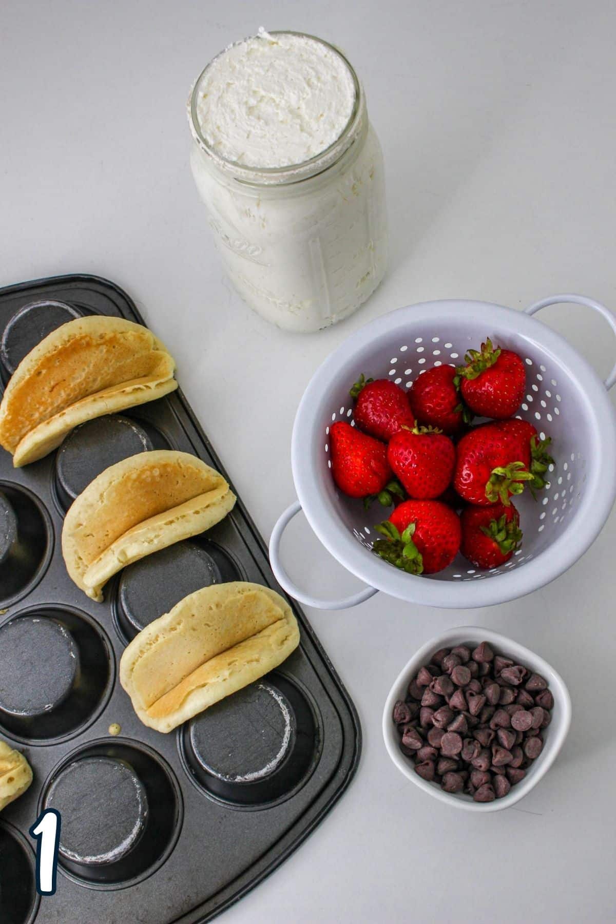Ingredients shown to make pancake tacos filled with strawberries. 