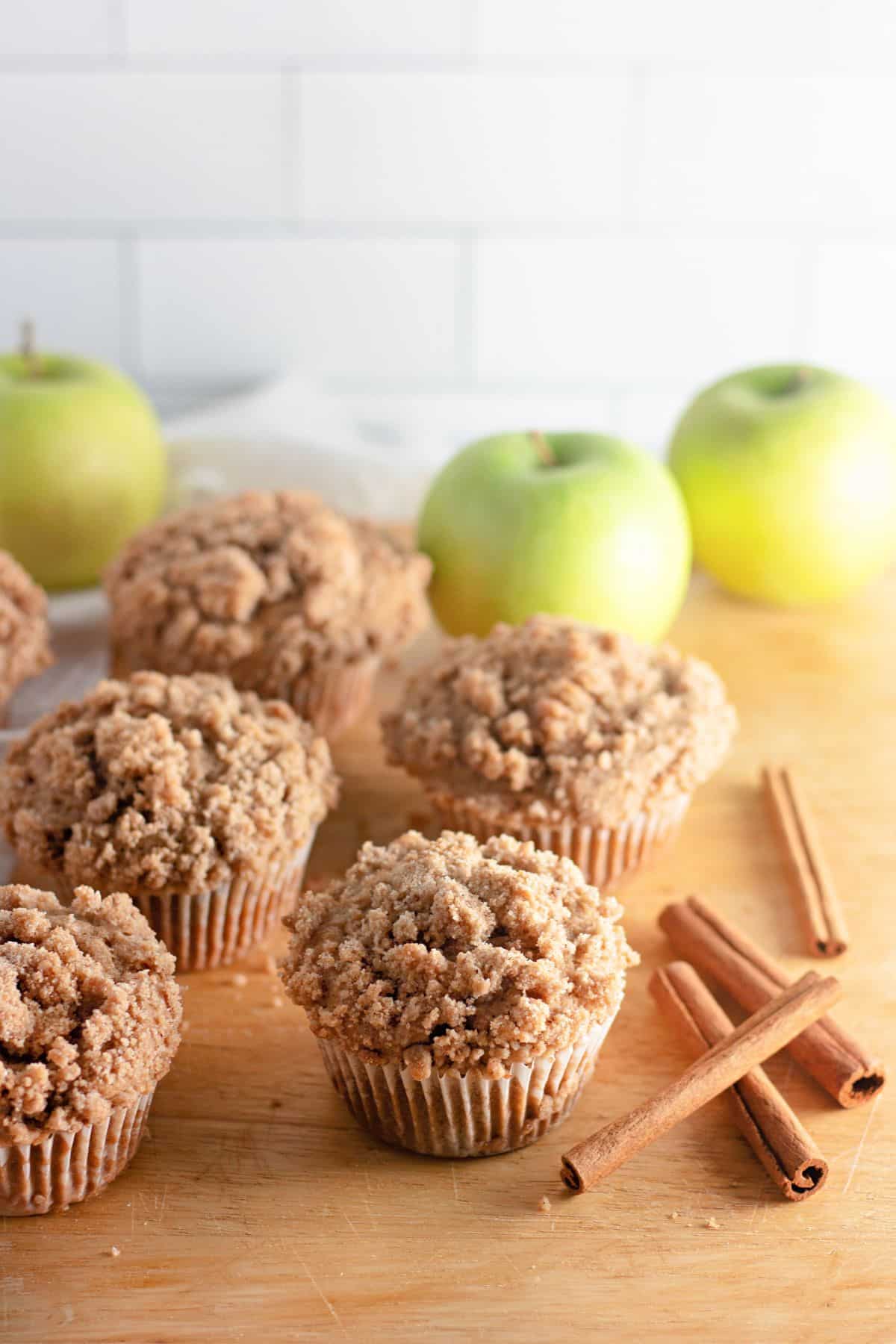 The Apple Cinnamon Muffins are on a wooden cutting board.
