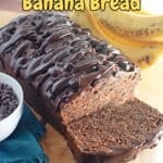 Triple chocolate banana bread on a cutting board, layered with rich cocoa and chunks of ripe bananas.
