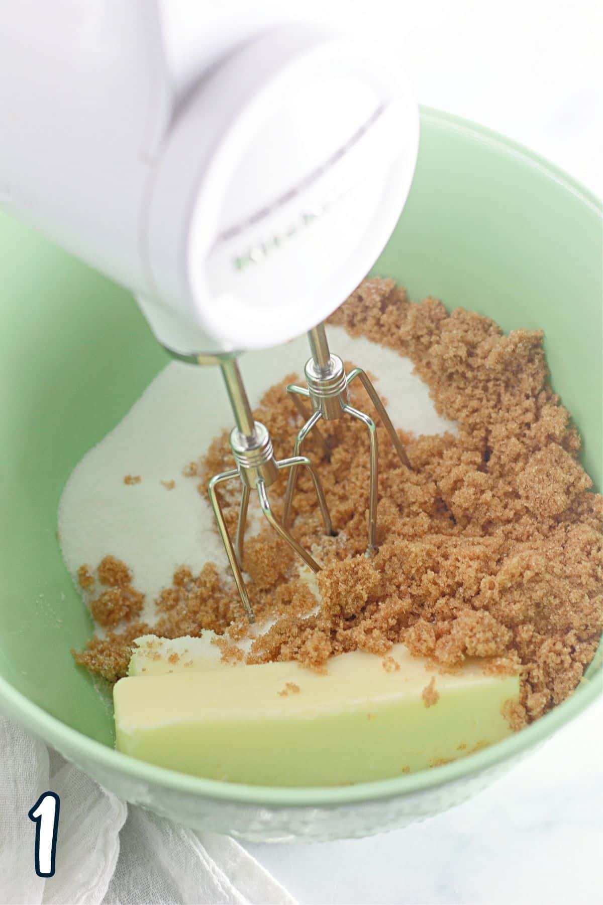 A mixer is being used to mix ingredients in a bowl.
