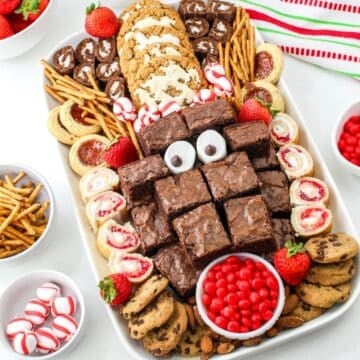 A christmas dessert tray with brownies, cookies and candies.