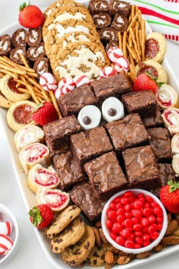 A christmas dessert tray with brownies, cookies and candies.