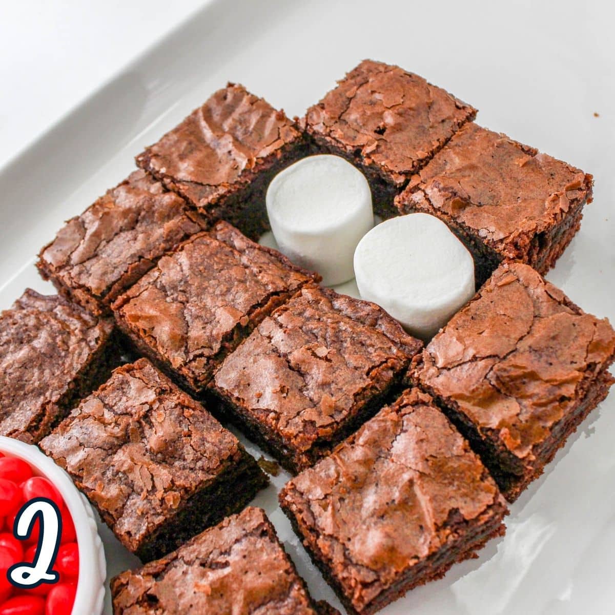 A plate with brownies and marshmallows on it.