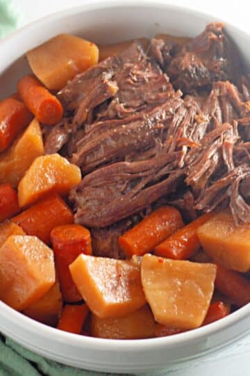 A bowl of beef stew with carrots and potatoes.