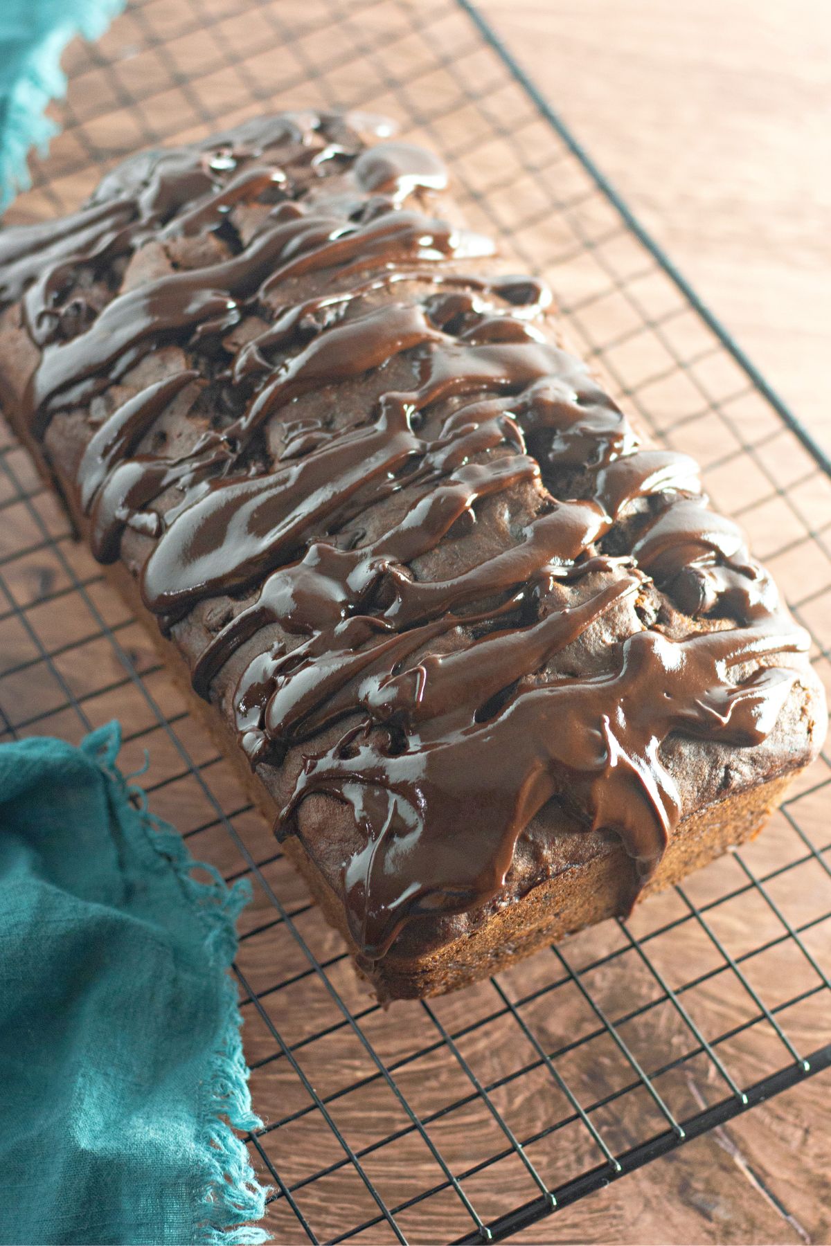 A chocolate cake on a cooling rack.