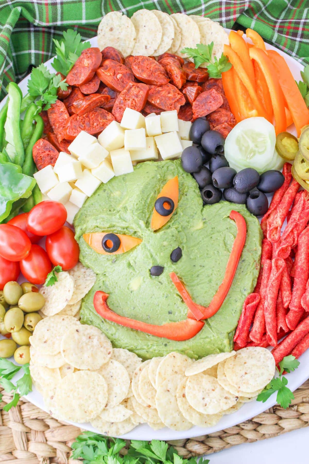 A plate with a grinch face and vegetables on it.