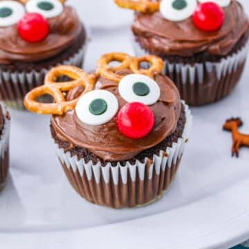 Chocolate reindeer cupcakes with pretzels on a plate.