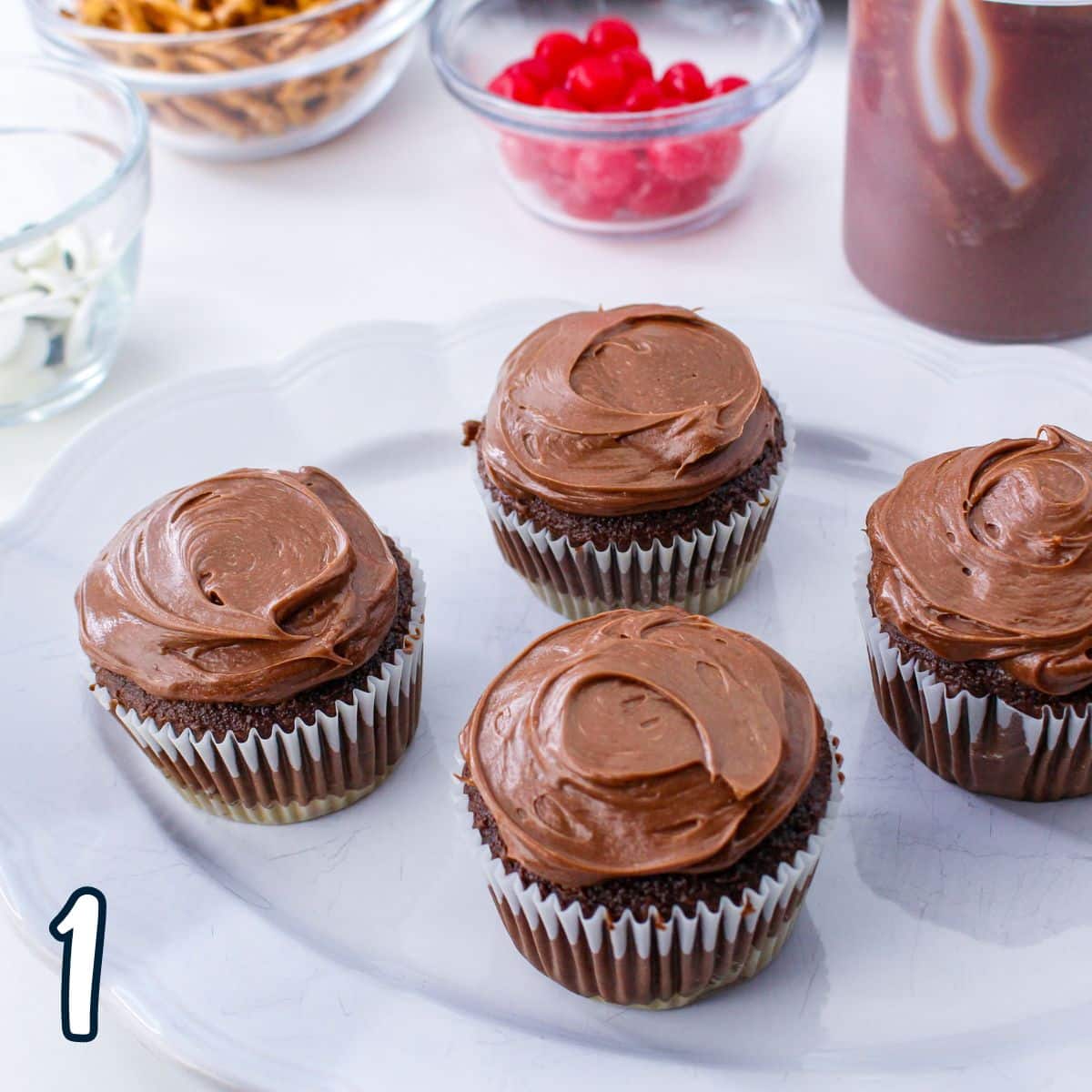 Chocolate cupcakes with chocolate frosting on a plate.