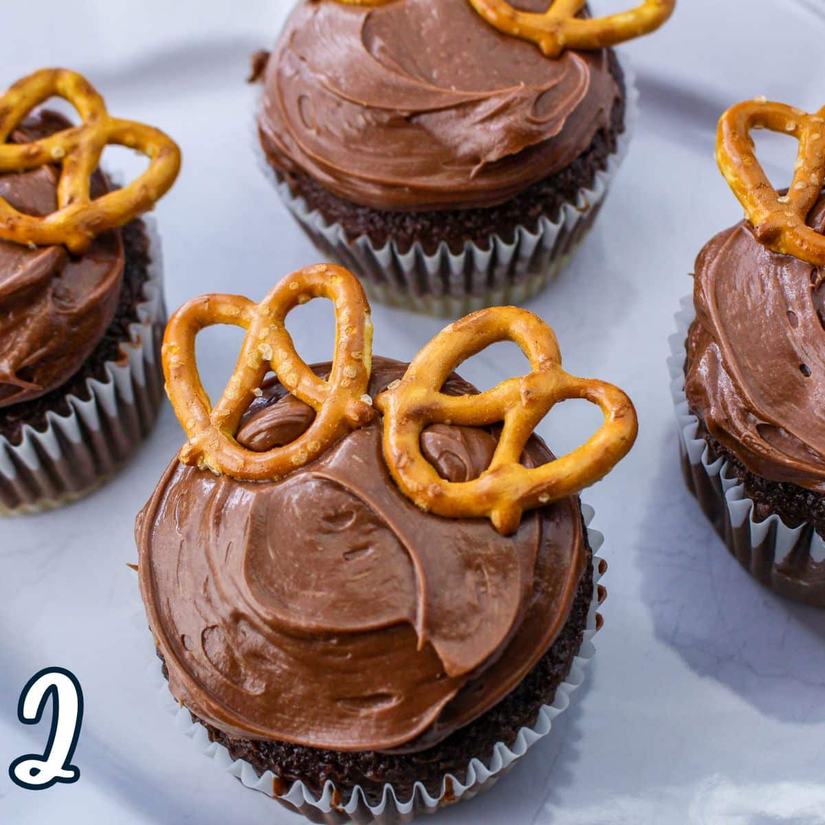 Chocolate cupcakes with pretzels on a plate.