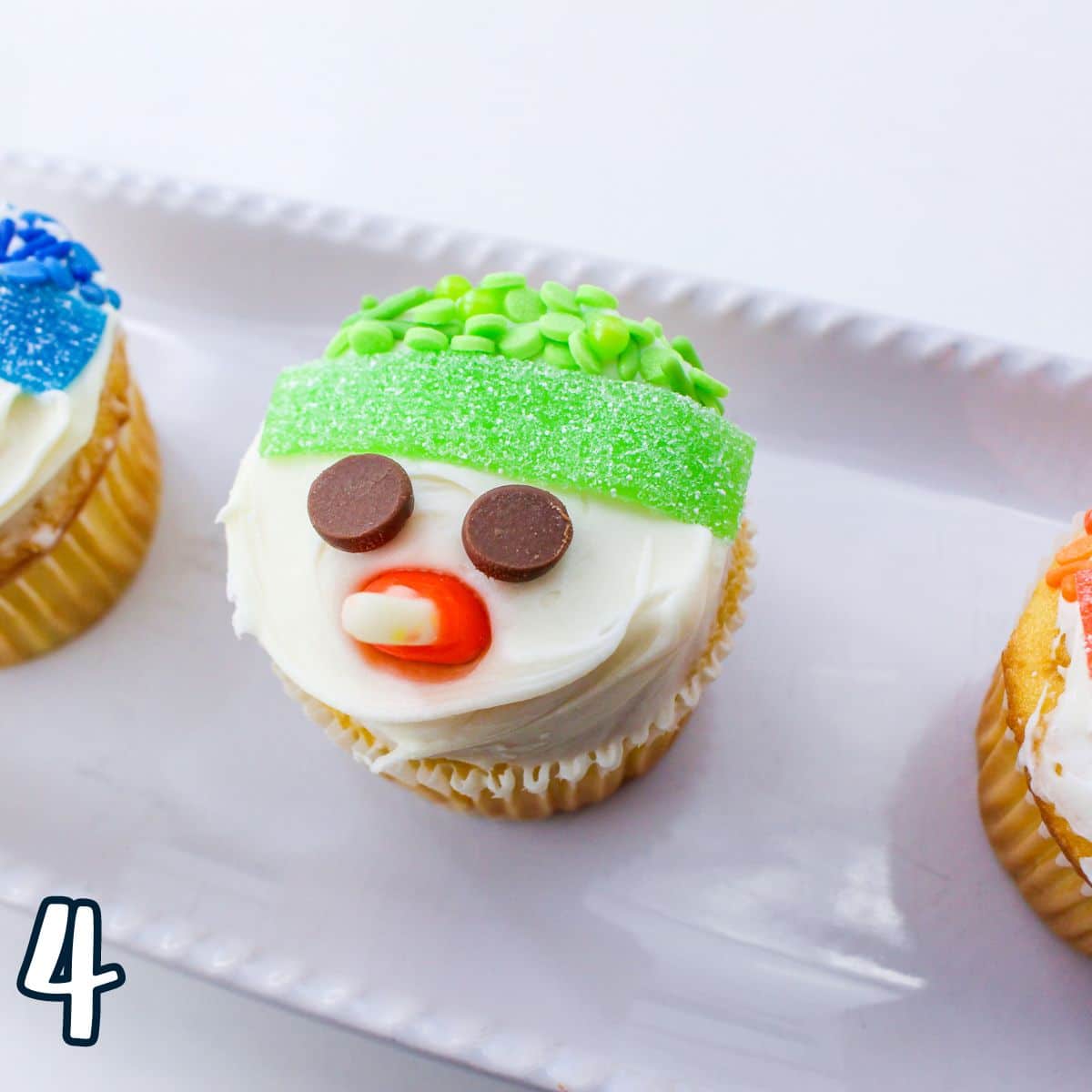 Snowman cupcakes displayed on a white plate.