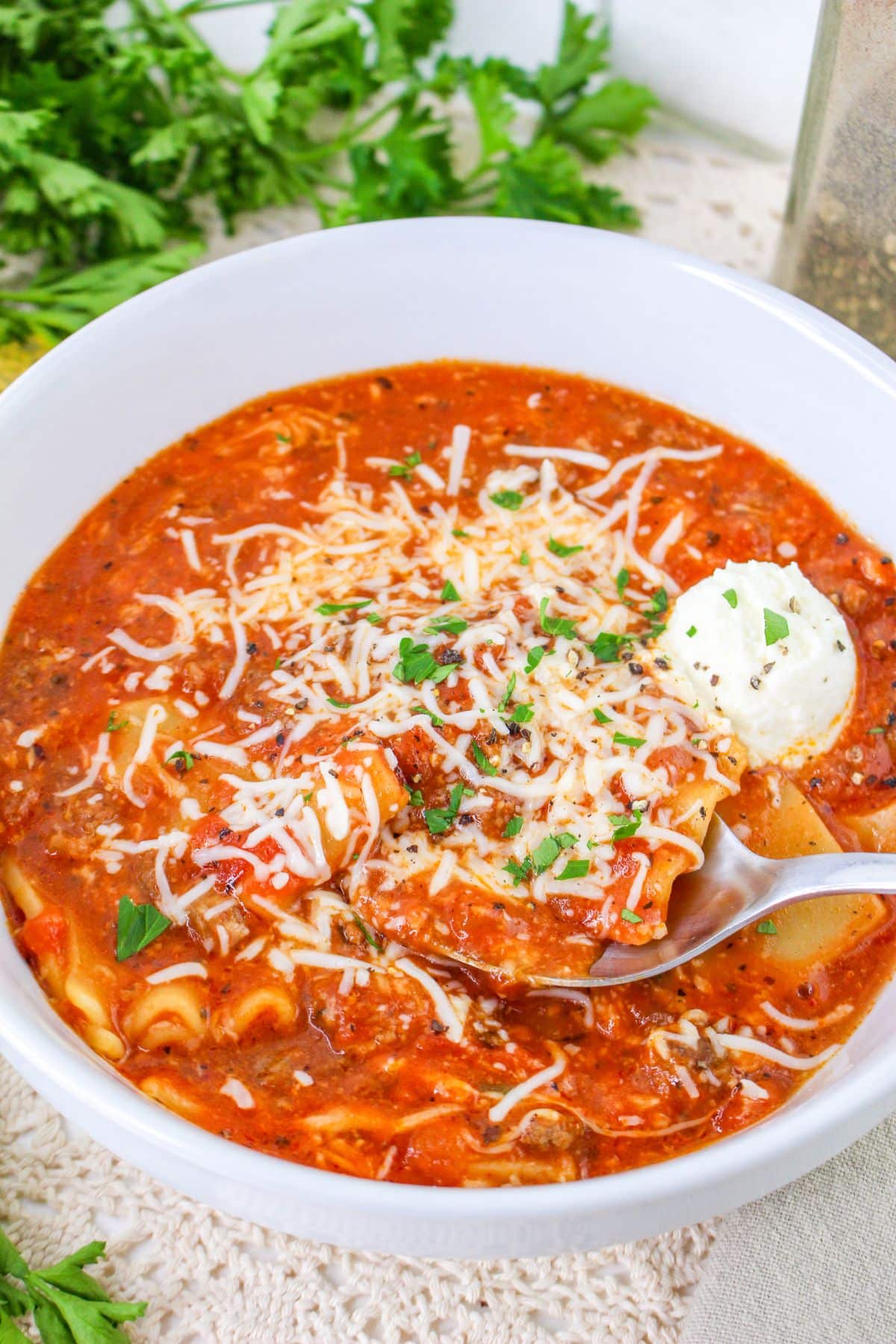 A bowl of lasagna soup with a spoon.
